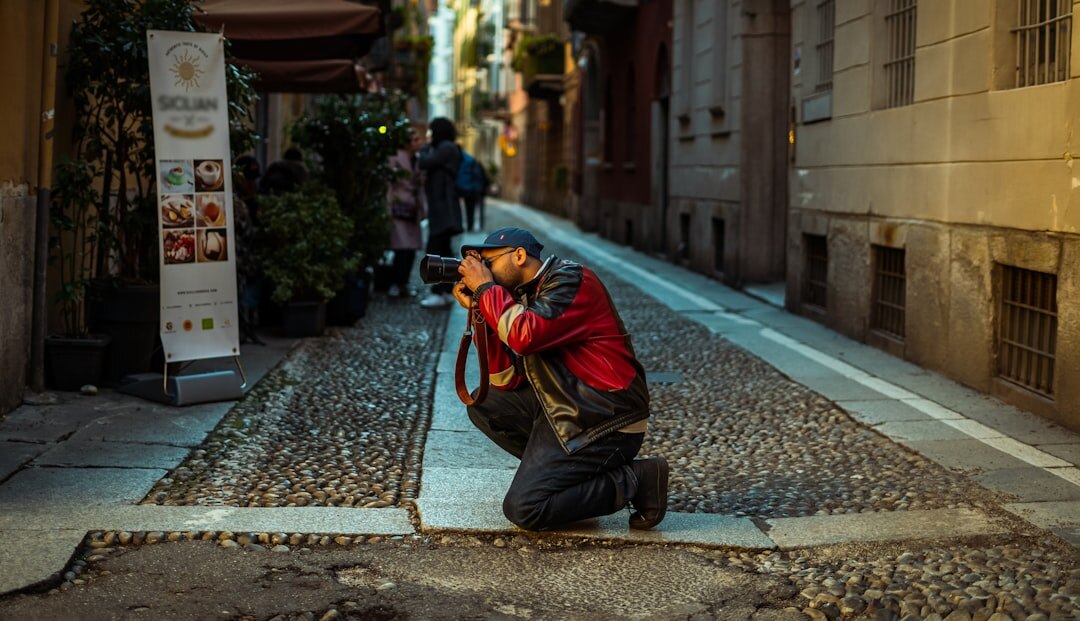 Photographer crouching to take a photo outdoors during a reportage trip